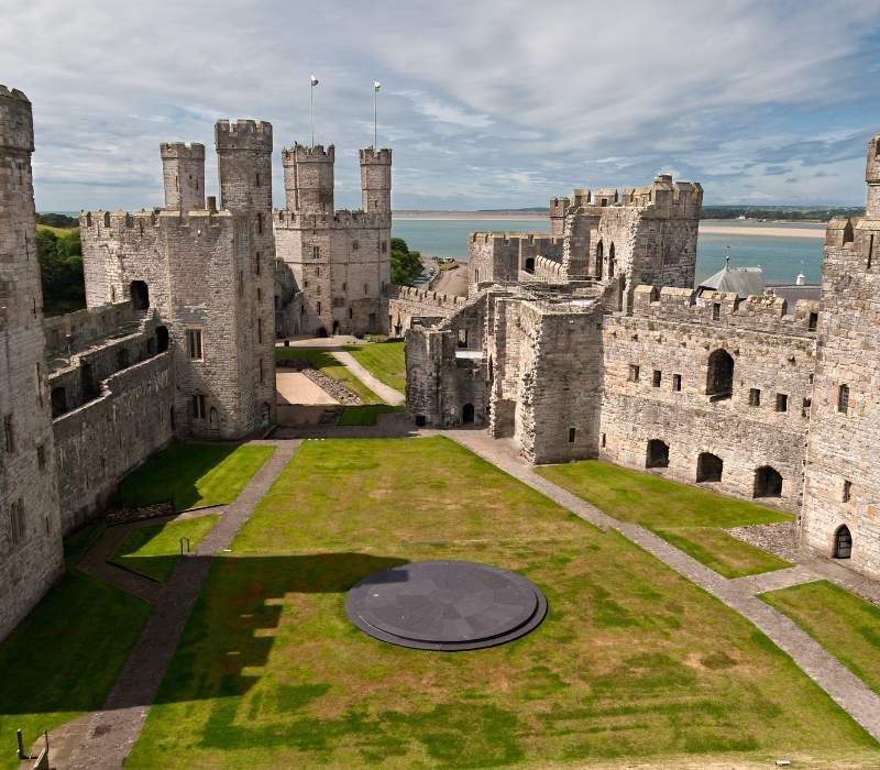 Historic Caernarfon Castle surrounded by the Snowdonia landscape, Wales