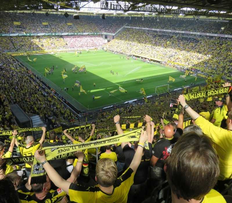 People watching a live soccer game in a crowded stadium